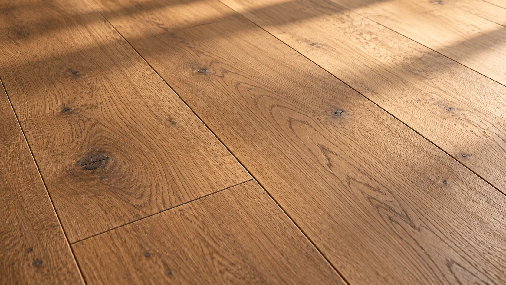 Close view of warm natural oak, with visible grain, knots and narrow plank seams in afternoon light.